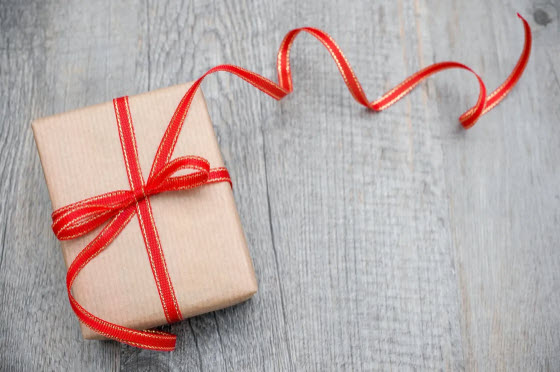 A beautifully wrapped gift with a red ribbon, representing how your message will be delivered